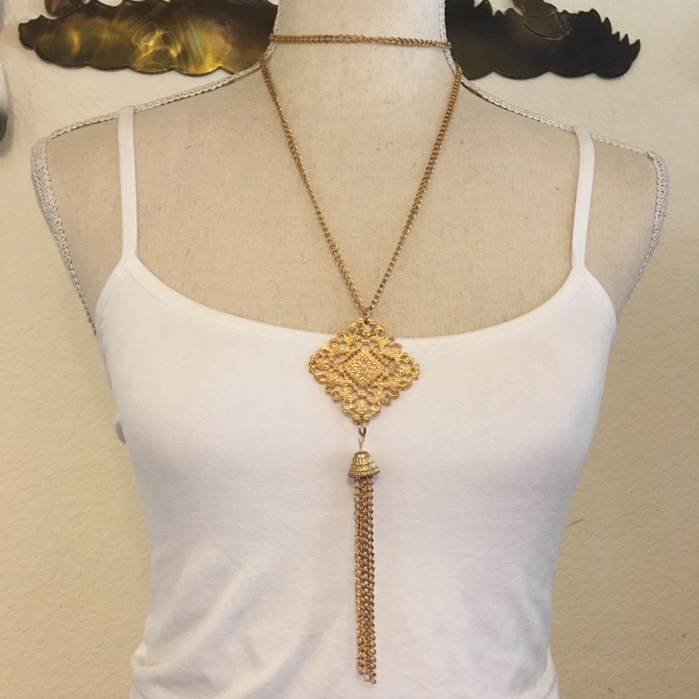 Gold tone medallion tassel pendant on chain link